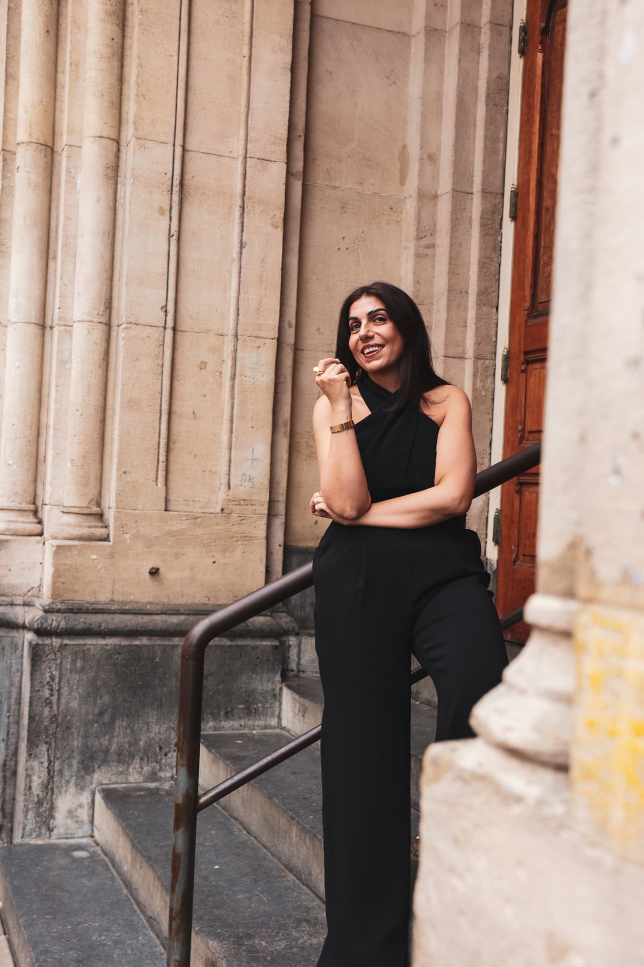 Hatice Tekin, founder of The Iconic Founder, smiling beside classical stone columns
